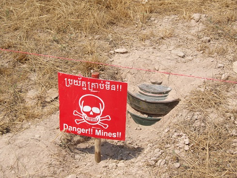 Landmine next to red warning sign 