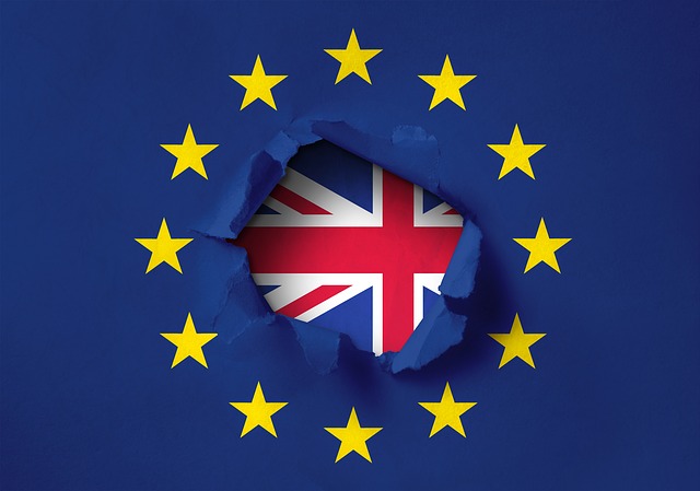Brexit Union Flag behind a tear in EU Flag