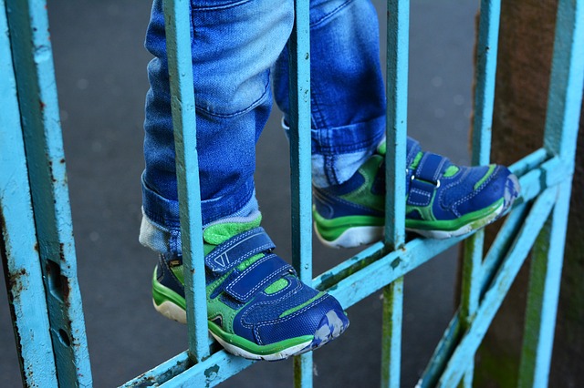 Child climbing on gate