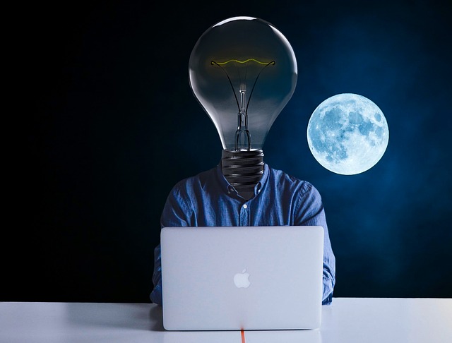 Person at laptop with light bulb head