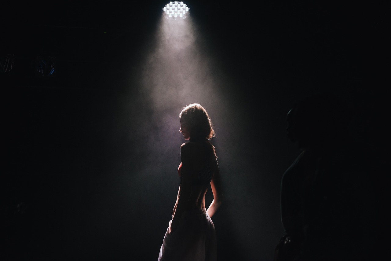 Woman standing in spotlight on stage