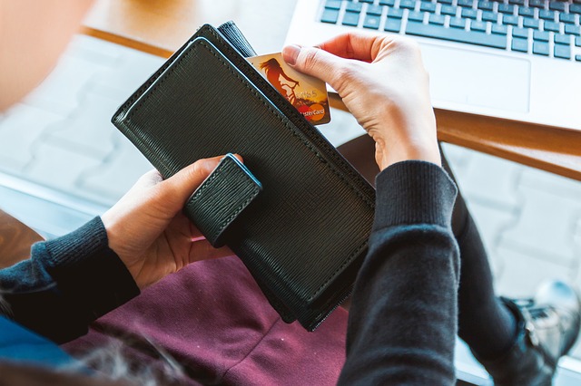 Woman putting card in black wallet